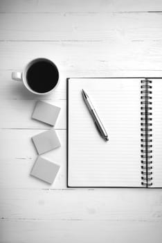 notepad and coffee cup on white table view from above black and white tone color style