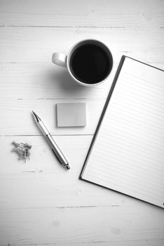 notepad and coffee cup on white table view from above black and white tone color style