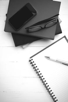 notepad with stack of book on table view from above black and white tone color style