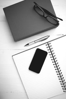 notepad with stack of book on table view from above black and white tone color style