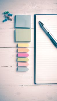 notepad with office supplies on white table view from above vintage style