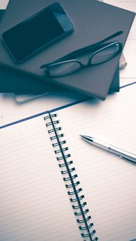 notepad with stack of book on white table view from above vintage style