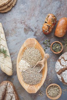 Assorted bread, bread rolls and  various seeds for baking. Ingredients for bread preparation, top view, vintage style