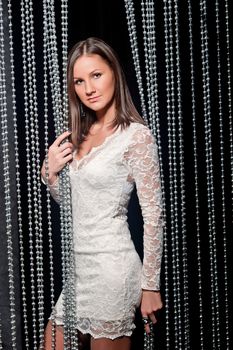 beautiful sexy girl in a white lace dress in the studio