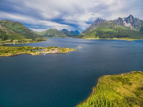 Picturesque fjord and mountain peaks around Sildpollnes Church on Lofoten islands in Norway, aerial view