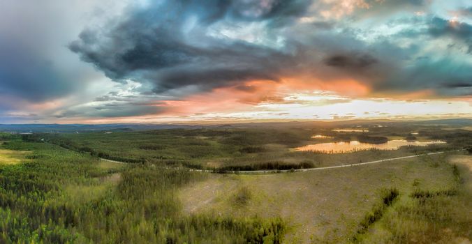 Aerial panorama of storm clouds over the forests during sunset in Sweden