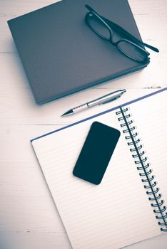 notepad with stack of book on white table view from above vintage style