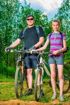portrait of a couple of athletes with bicycles on a sunny day