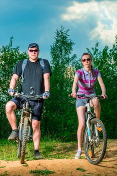 man and woman with bicycles on a country road
