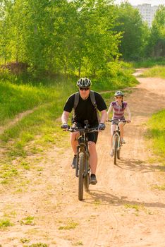 bicycles ride on a country road in helmets