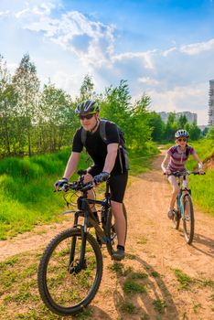 Young family on bike exercising on a country road