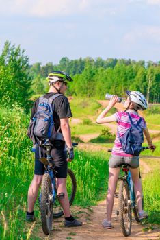 young athletes on bicycles rest and drink water