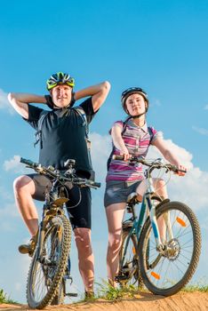a couple of cyclists in helmets on bikes posing