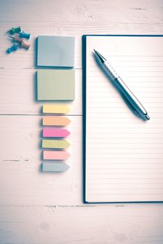 notepad with office supplies on white table view from above vintage style