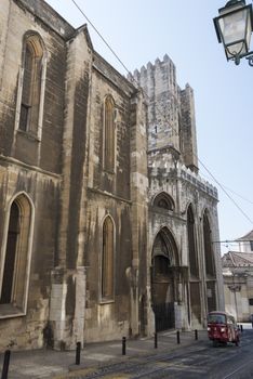 old church in city Lisbon with tuk tuk taxi in the street