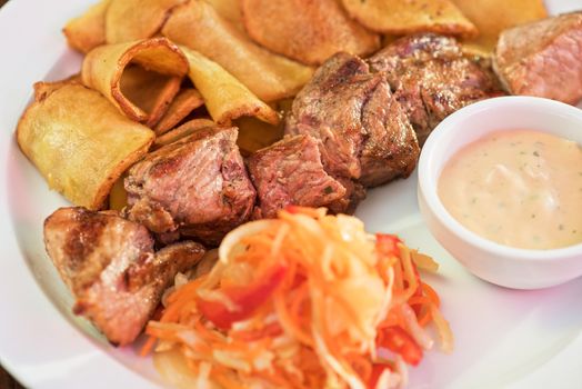Grilled pork, baked potatoes and vegetable salad