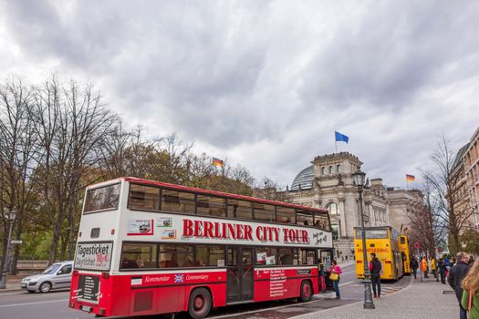 Berlin, Germany - October 28, 2013: Sightseeing buses in front of the Reichstag building. The different bus companies approach the most interesting places of Berlin.