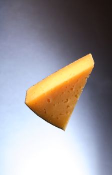 Piece of Gruyere cheese on nice dark background