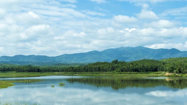 landscape with mountains trees and a river in front