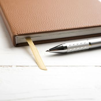 notebook and pen over white table