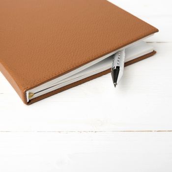 notebook and pen over white table