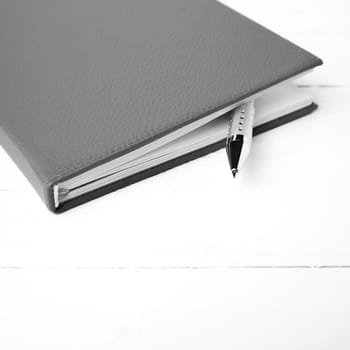 notebook and pen over white table black and white tone color style