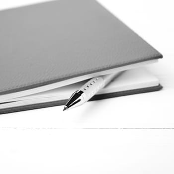 notebook and pen over white table black and white tone color style