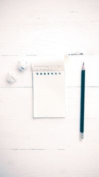 notepad with crumpled paper and pencil over white table vintage style