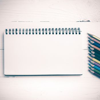 notepad with color pencil on white table view from above vintage style