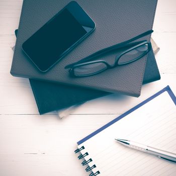 notepad with stack of book on white table view from above vintage style