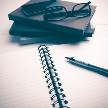 notepad with stack of book on white table vintage style