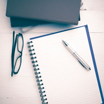 notepad with stack of book on white table view from above vintage style