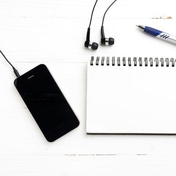 notepad and cellphone over white table