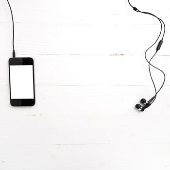 cellphone with earphone over white table