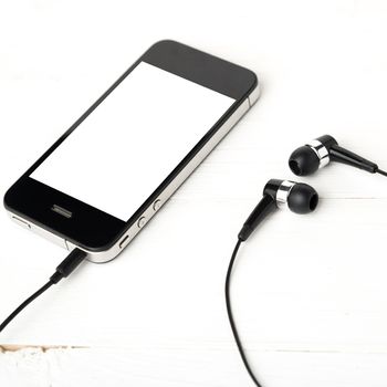 cellphone with earphone over white table