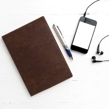 cellphone and notebook over white table