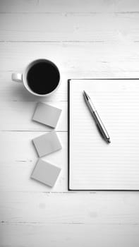 notepad and coffee cup on white table view from above black and white tone color style