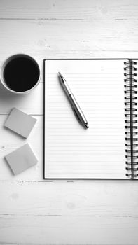 notepad and coffee cup on white table view from above black and white tone color style