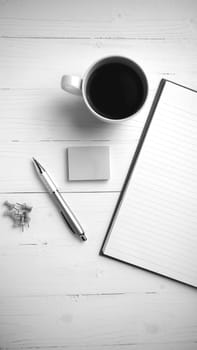 notepad and coffee cup on white table view from above black and white tone color style