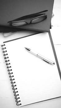 notepad with stack of book on table view from above black and white tone color style