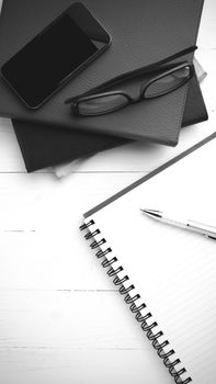 notepad with stack of book on table view from above black and white tone color style