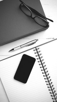 notepad with stack of book on table view from above black and white tone color style