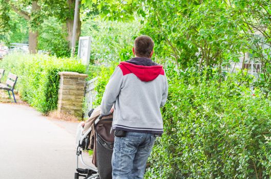 Grandpa with grandson walking with pram on a walk.