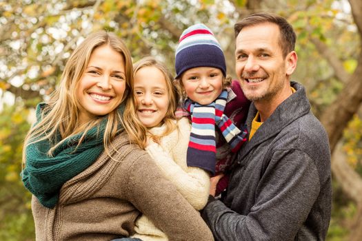 Smiling young family posing together on an autumns day