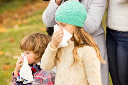 Sick family blowing their noses on an autumns day