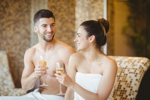 Romantic couple together with champagne glasses at the spa