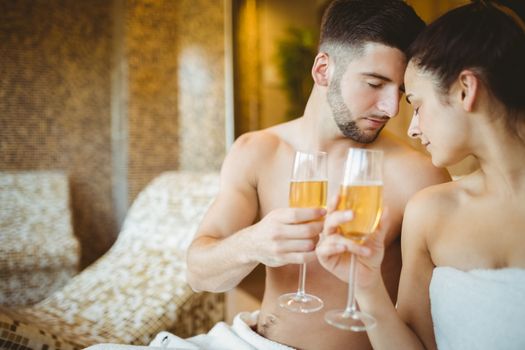 Romantic couple together with champagne glasses at the spa