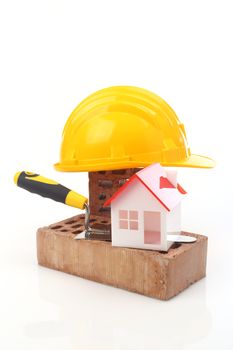 Bricks, trowel and helmet over white 