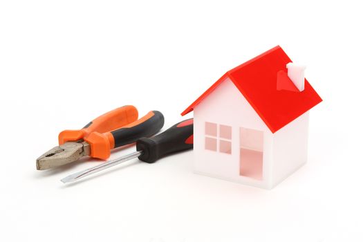 model of house and tools over white