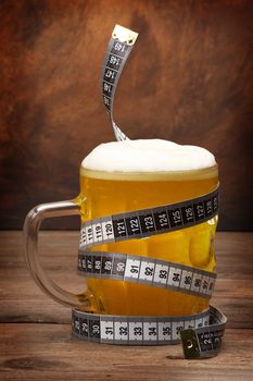 Beer mug and tape measure . Diet concept